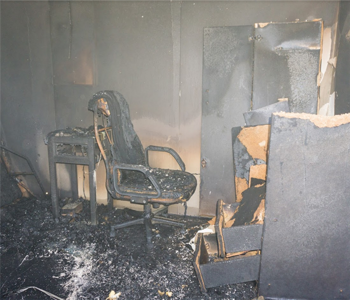 a fire damaged office with soot and debris covering everything
