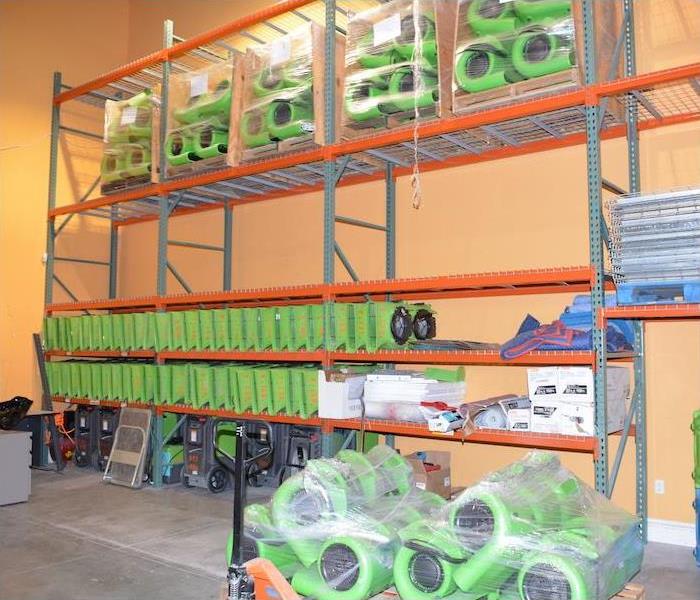 Warehouse with green SERVPRO equipment on orange shelves